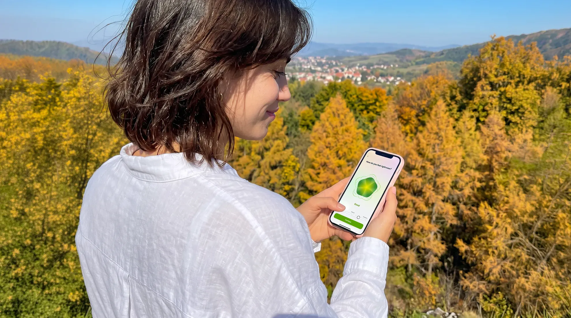 a young woman is holding smartphone with the mood tracker by Liven opened